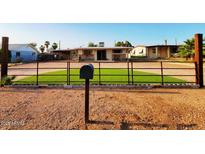Ranch style home with artificial turf and a metal fence at 8122 E Broadway Rd, Mesa, AZ 85208