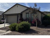 One-story home with gray siding, a two-car garage, and landscaping at 1094 S 151St S Ln, Goodyear, AZ 85338