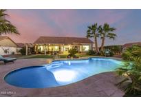 Inviting pool with a spacious deck and landscape lighting at dusk at 14316 W Circle Ridge Dr, Sun City West, AZ 85375