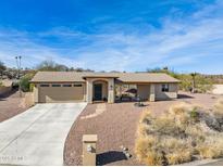 One-story home with a beige exterior, attached garage, and landscaped front yard at 15212 N Palmetto Ln, Fountain Hills, AZ 85268