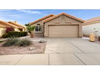 Tan house with tile roof, two-car garage, and desert landscaping at 2023 E Glenhaven Dr, Phoenix, AZ 85048