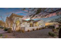 Stucco home featuring gravel landscaping, tile roof, and desert plants in front yard at sunset at 20641 W Medlock Dr, Buckeye, AZ 85396