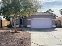 Charming single-story home featuring a two-car garage, desert landscaping, and a cozy front yard tree at 4043 E Arbor Ave, Mesa, AZ 85206