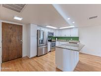 Modern kitchen featuring stainless steel appliances, center island, and white cabinets at 7930 E Camelback Rd # 509, Scottsdale, AZ 85251