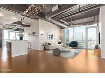 Open living area with hardwood floors, city views, and modern furniture at 1 E Lexington Ave # 908, Phoenix, AZ 85012