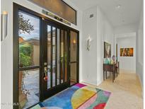 Bright and spacious entryway with a large black front door, colorful rug, and artwork at 11127 E Mirasol Cir, Scottsdale, AZ 85255