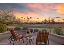Peaceful patio with fire pit, chairs, and scenic golf course views at 19528 N Crescent Ridge Dr, Surprise, AZ 85387