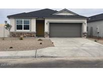 Charming single-story home featuring stone accents, a two-car garage, and low maintenance desert landscaping at 97 S Collier Ln, Casa Grande, AZ 85122