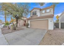 Two-story house with tan exterior, two-car garage, and landscaped front yard at 13638 W Desert Flower Dr, Goodyear, AZ 85395