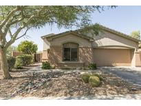 Inviting single-story home featuring a desert-landscaped yard, a two-car garage, and a charming front entrance at 2335 W Muirfield Dr, Anthem, AZ 85086