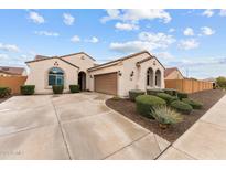 Single-story home with a two-car garage and well-manicured landscaping at 26011 W Wahalla Ln, Buckeye, AZ 85396