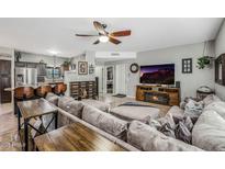 Open living area with sectional sofa, fireplace, and large TV at 37213 N 17Th Ave, Phoenix, AZ 85086