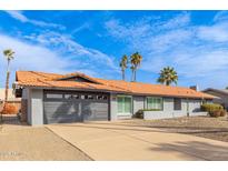 Charming home with a two-car garage, driveway, gray exterior, orange roof, and landscaped front yard at 502 E Le Marche Ave, Phoenix, AZ 85022