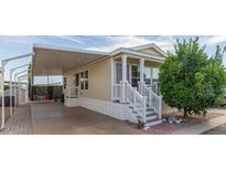 Tan mobile home with covered patio, white railing, and landscaping at 8700 E University Dr # 1315, Mesa, AZ 85207