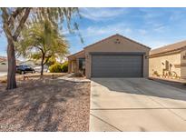 Tan house with gray garage door and walkway leading to entry at 1353 E Kelsi Ave, San Tan Valley, AZ 85140