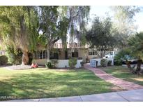 Cute ranch home with brick pathway, lush lawn, and mature trees at 1526 W Wilshire Dr, Phoenix, AZ 85007
