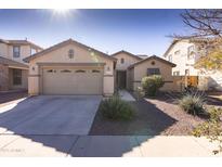 Single-story home with a two-car garage and desert landscaping at 16425 W Honeysuckle Dr, Surprise, AZ 85387