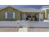 Charming single-story home with a white brick fence and front porch seating under an Arizona blue sky at 2929 E Broadway Rd # 44, Mesa, AZ 85204