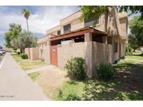 Tan stucco condo building with covered parking and a grassy area at 4002 W Palomino Rd, Phoenix, AZ 85019