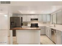 Modern kitchen with stainless steel appliances and an island at 6031 E Evans Dr, Scottsdale, AZ 85254