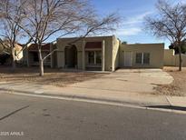 Tan stucco house with red tile roof, arched entryway, and mature trees at 717 W Chilton St, Chandler, AZ 85225