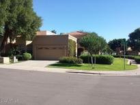 Tan two-story home with a two-car garage and well-manicured lawn at 9463 N 105Th N Pl, Scottsdale, AZ 85258