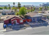 Aerial view of two houses with surrounding neighborhood and city skyline in background at 1021 E Roosevelt St, Phoenix, AZ 85006