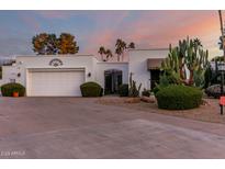 Beautiful home with a two-car garage, lovely front garden, and private front entry under a colorful sunset at 145 E Boca Raton Rd, Phoenix, AZ 85022