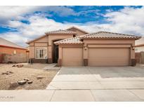 Tan two-story house with a two-car garage and desert landscaping at 15825 W Durango St, Goodyear, AZ 85338