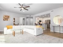 Open living room with white sectional sofa and view of kitchen at 17850 N 68Th St # 2145, Phoenix, AZ 85054