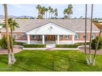 Stunning brick home featuring white columns, grand entryway, mature palms, and lush front lawn at 1859 N Val Vista Dr, Mesa, AZ 85213