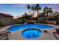 Swimming pool and spa with waterfall feature at dusk at 4808 N Litchfield E Knl, Litchfield Park, AZ 85340