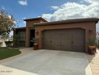 One-story home with brown exterior, landscaped yard, and two-car garage at 1803 E Sattoo Way, Queen Creek, AZ 85140