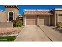 Two-car garage with Spanish-style architecture and landscaping at 25239 S Glenburn Dr, Sun Lakes, AZ 85248