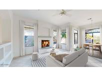 Cozy living room with a fireplace, ample natural light, and access to the dining area at 8227 E Sierra Pinta Dr, Scottsdale, AZ 85255