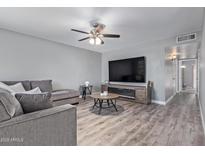 Bright living room features L-shaped sofa, wood-look floors, and a modern fireplace at 10009 N 97Th Dr # A, Peoria, AZ 85345