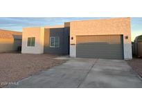 Modern stucco home with gray garage door and gravel driveway at 14825 S Charco Rd, Arizona City, AZ 85123