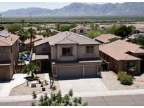 Two-story home featuring desert landscaping, a spacious driveway, and a two-car garage in a community setting with mountain views at 1801 W Nighthawk Way, Phoenix, AZ 85045