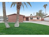 Ranch style home with brick facade, landscaped lawn, and attached garage at 3609 W Royal Palm Rd, Phoenix, AZ 85051