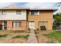 Two-story townhome with brown and white exterior, landscaping, and a walkway at 4354 W Maryland Ave, Glendale, AZ 85301