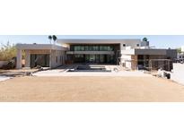 Modern home exterior with expansive backyard, pool, and large windows at 7432 E Wethersfield Rd, Scottsdale, AZ 85260