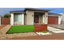 Modern single-story home with a wood-like garage door and artificial turf at 1010 E Pierson St, Phoenix, AZ 85014
