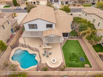 Stunning aerial view of a home featuring a private pool, patio with pergola, fire pit, and well-manicured lawn at 3241 E Aris Dr, Gilbert, AZ 85298