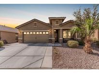 Inviting single-story home featuring a two-car garage, desert landscaping, and a covered entryway at 514 S 224Th Dr, Buckeye, AZ 85326