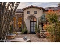 Stunning stone exterior with arched entryway and desert landscaping at 27256 N 97Th Pl, Scottsdale, AZ 85262