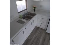 Bright kitchen featuring double sink, white cabinets, and modern flooring at 303 S Recker Rd # 126, Mesa, AZ 85206