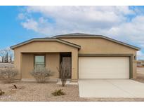 Tan house with a white garage door and landscaping at 3715 N Algodon Dr, Eloy, AZ 85131