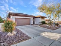 Single-story home with brown garage door and landscaped yard at 41933 N Crooked Stick Rd, Anthem, AZ 85086