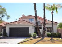 Cute two-story home with tile roof and landscaped lawn at 9573 E Dreyfus Pl, Scottsdale, AZ 85260