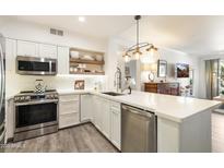 Bright kitchen with stainless steel appliances, white cabinets, countertops and open shelves for easy access at 20100 N 78Th Pl # 1040, Scottsdale, AZ 85255
